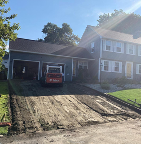 Bobcat in Driveway Prepping for Paving by John Cooper Asphalt Paving in Rhode Island
